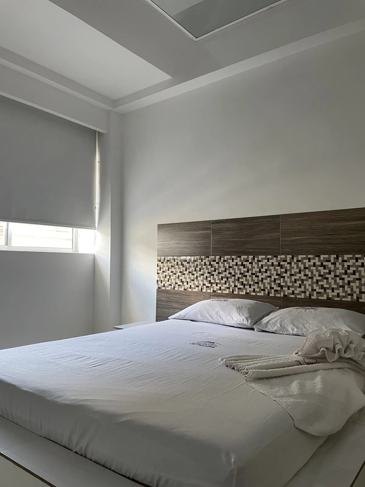 Suite Sencilla · cama con cabecero en madera